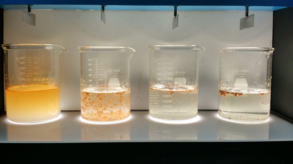 Water treatment chemical samples in laboratory beakers